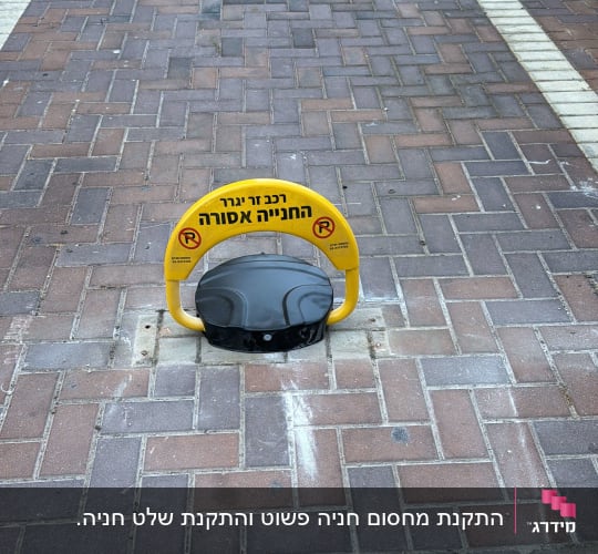 מחסום חניה צהוב על מדרכה מרוצפת